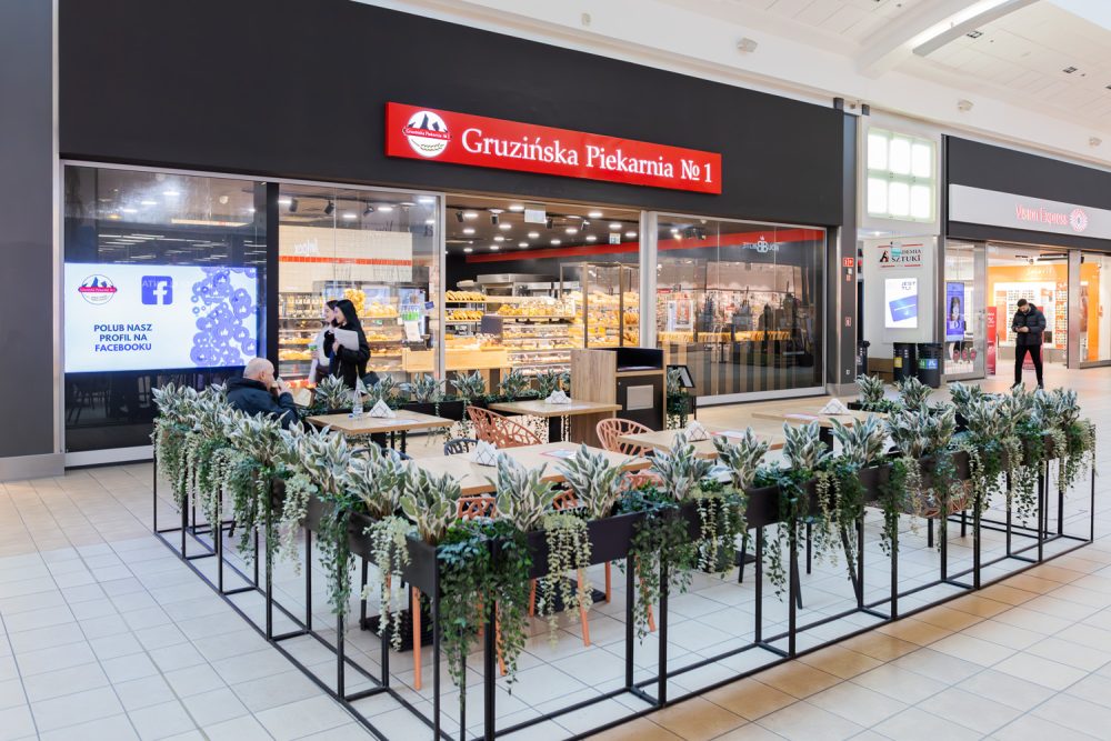Stoliki przed Gruzińską Piekarnią w M1 Kraków